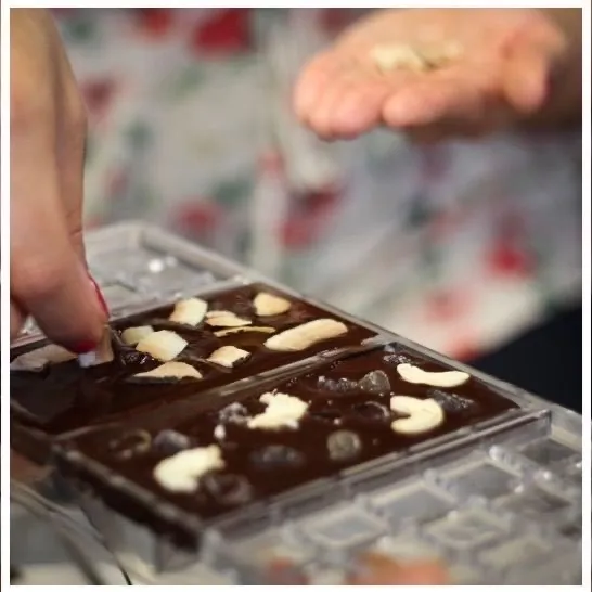 filling a chocolate mold during a chocolate making workshop